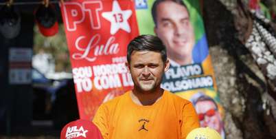 Um vendedor exibe bon&eacute;s &agrave; venda dos candidatos &agrave; presid&ecirc;ncia do Brasil, Luiz In&aacute;cio Lula da Silva e Fl&aacute;vio Bolsonaro, em um bairro residencial de Bras&iacute;lia, em 11 de setembro de 2026. Foto: RFI