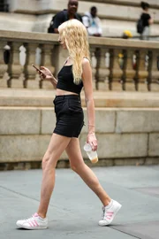 Mulher andando com um café gelado