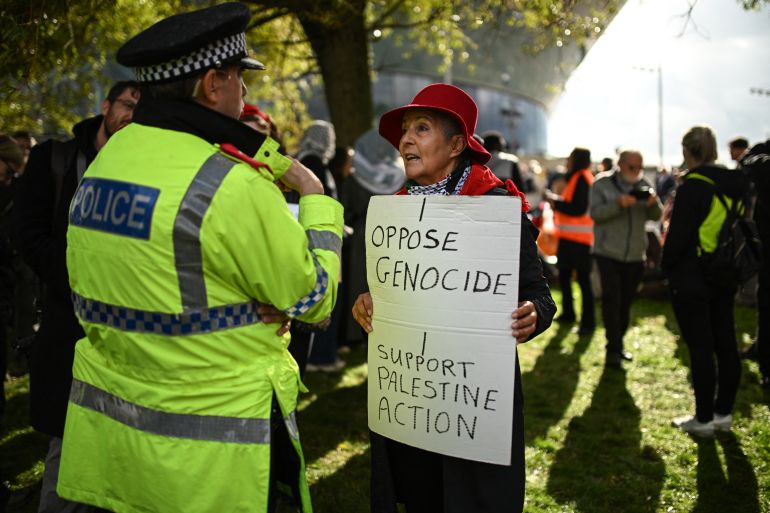 A policeman speaks to a supporter of the proscribed group Palestine Action as they gather to protest outside the conference venue on the first day of the annual Labour Party conference in Liverpool, north-west England on September 27, 2026 [Oli Scarff/AFP]