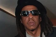 Jay-Z posa de óculos escuros e cara fechada