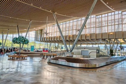 Interior of arrivals hall, with fans above luggage belts