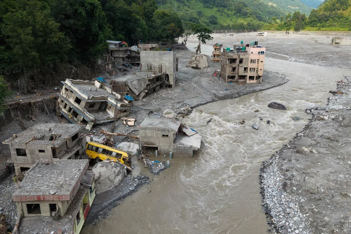 A torrent of muddy water surging past houses and through the Trishuli river in the aftermath of flash floods, at Betrawati in Nepal, on Aug 29.