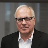 A man in a suit jacket wearing glasses