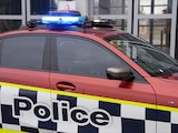 A red Australian Federal Police car from the side.