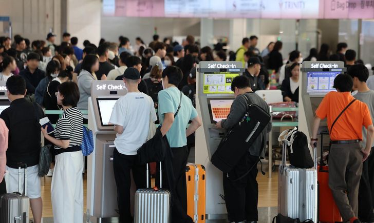 Travelers wait to check in to their flights at Terminal 1 of Incheon International Airport, west of Seoul, Sept. 23, ahead of the Chuseok holiday. Yonhap
