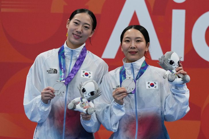 South Korea's Kim Su-ji, right, and Kim Na-hyun pose with their medals after winning silver in the women's synchronized 3m springboard final at the Asian Games in Tokyo, Japan, Sunday. AP-Yonhap