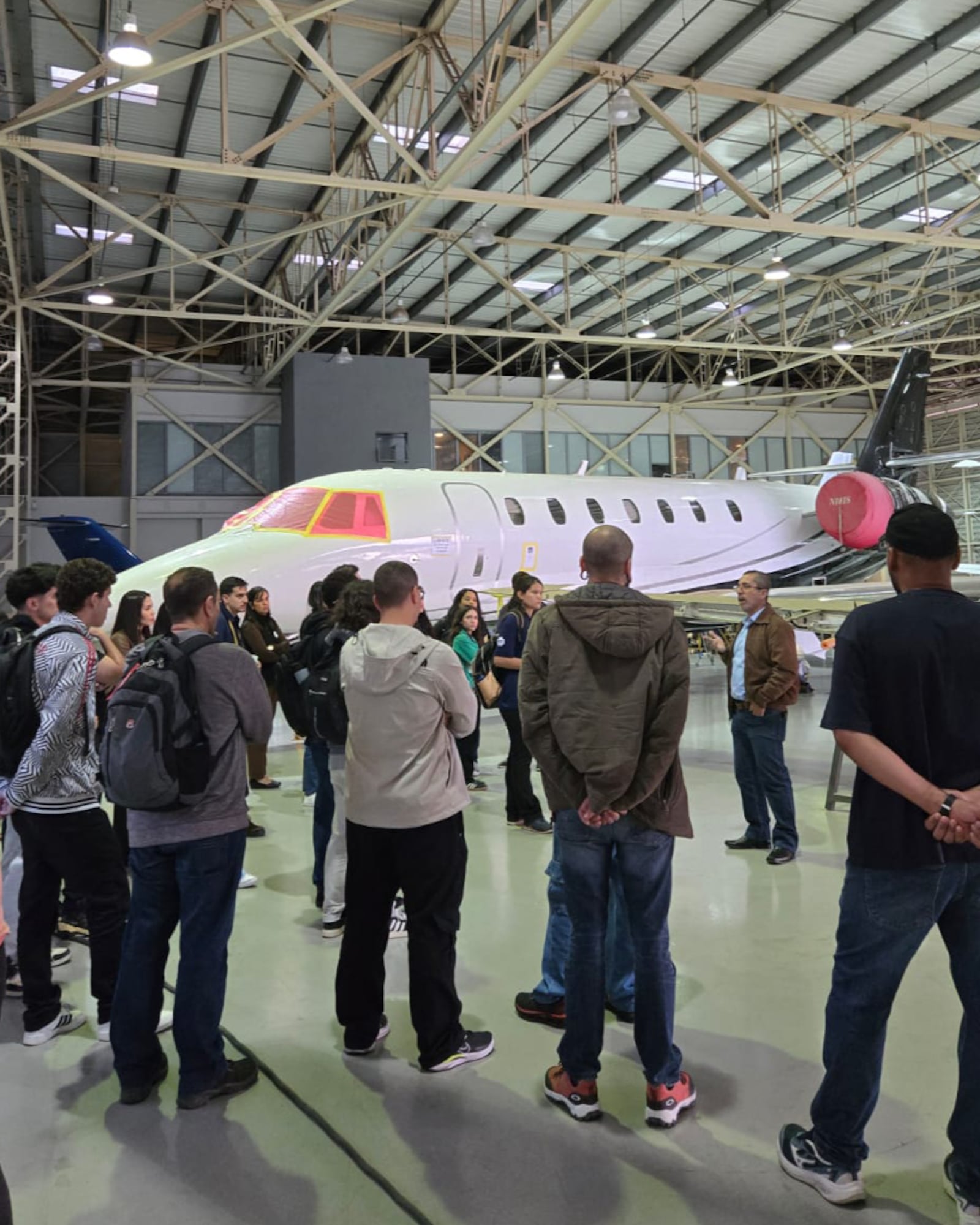 Grupo de estudantes e profissionais no hangar Voar Aviation