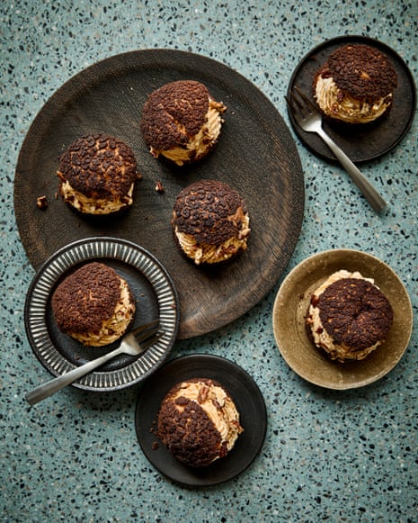 Chocolate and pumpkin spice choux buns with cream filling sit on dark plates