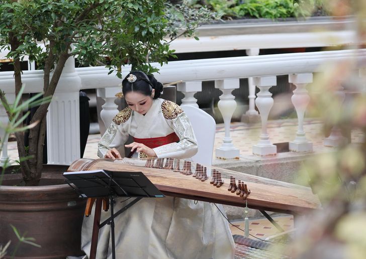 A musician plays the gayageum during a concert at Daeonsil, the historic glass greenhouse at Changgyeong Palace in Seoul, Monday. Yonhap